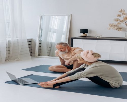 Senior woman doing gentle yoga on a mat in living room